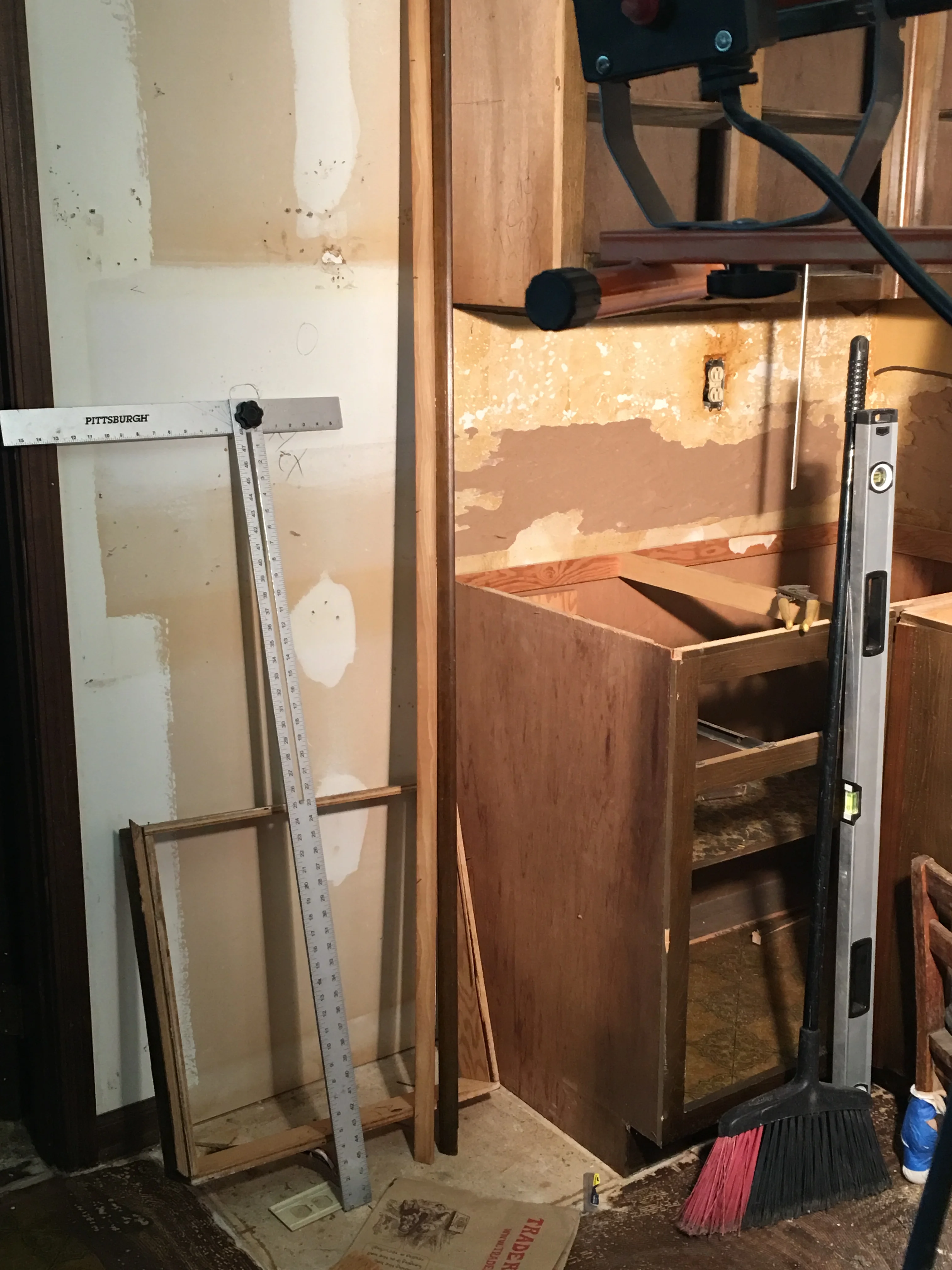 Kitchen demolition in progress with removed cabinets and drywall prep work