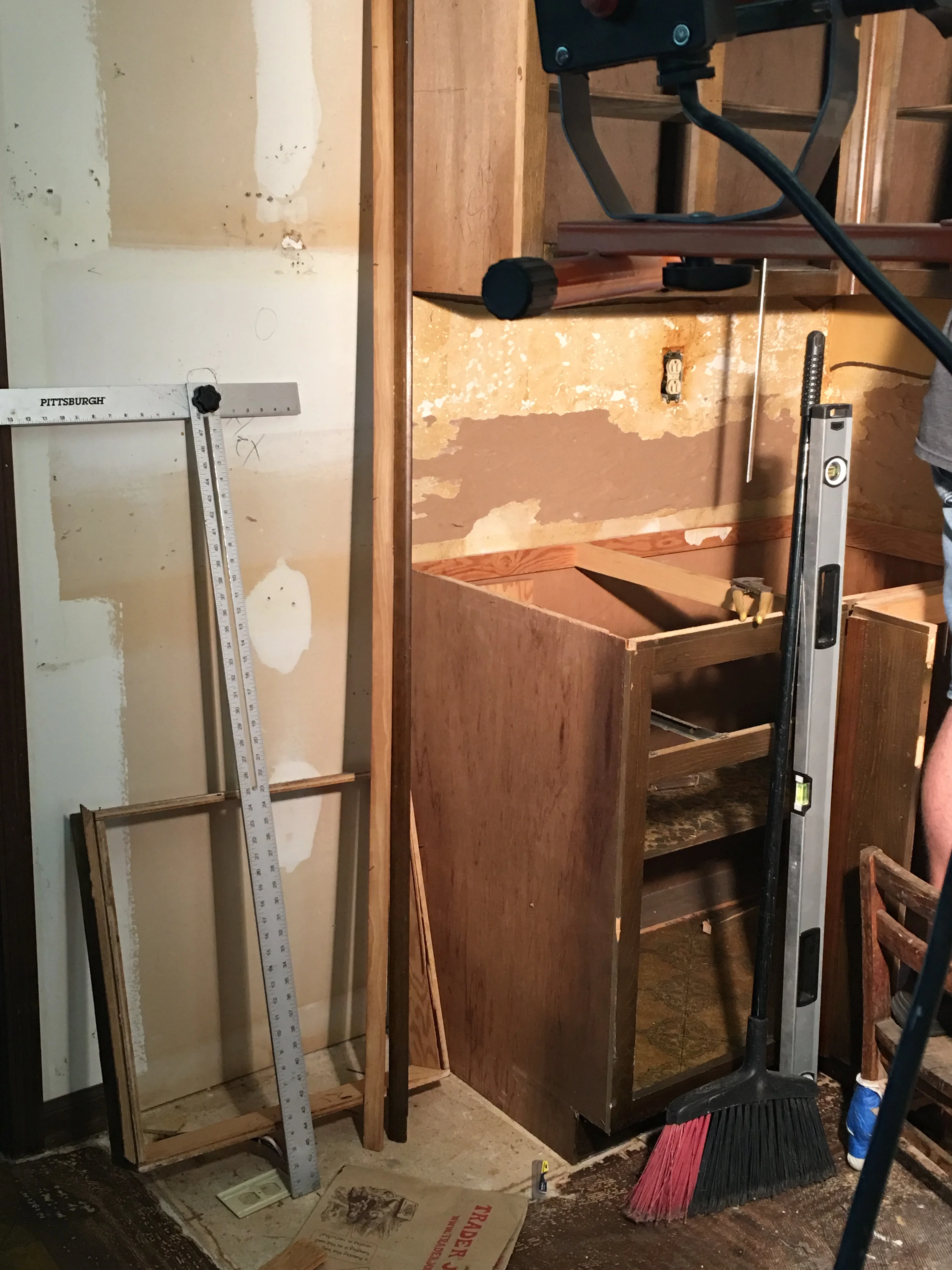 Kitchen remodeling in progress with wooden cabinetry framing and drywall preparation work