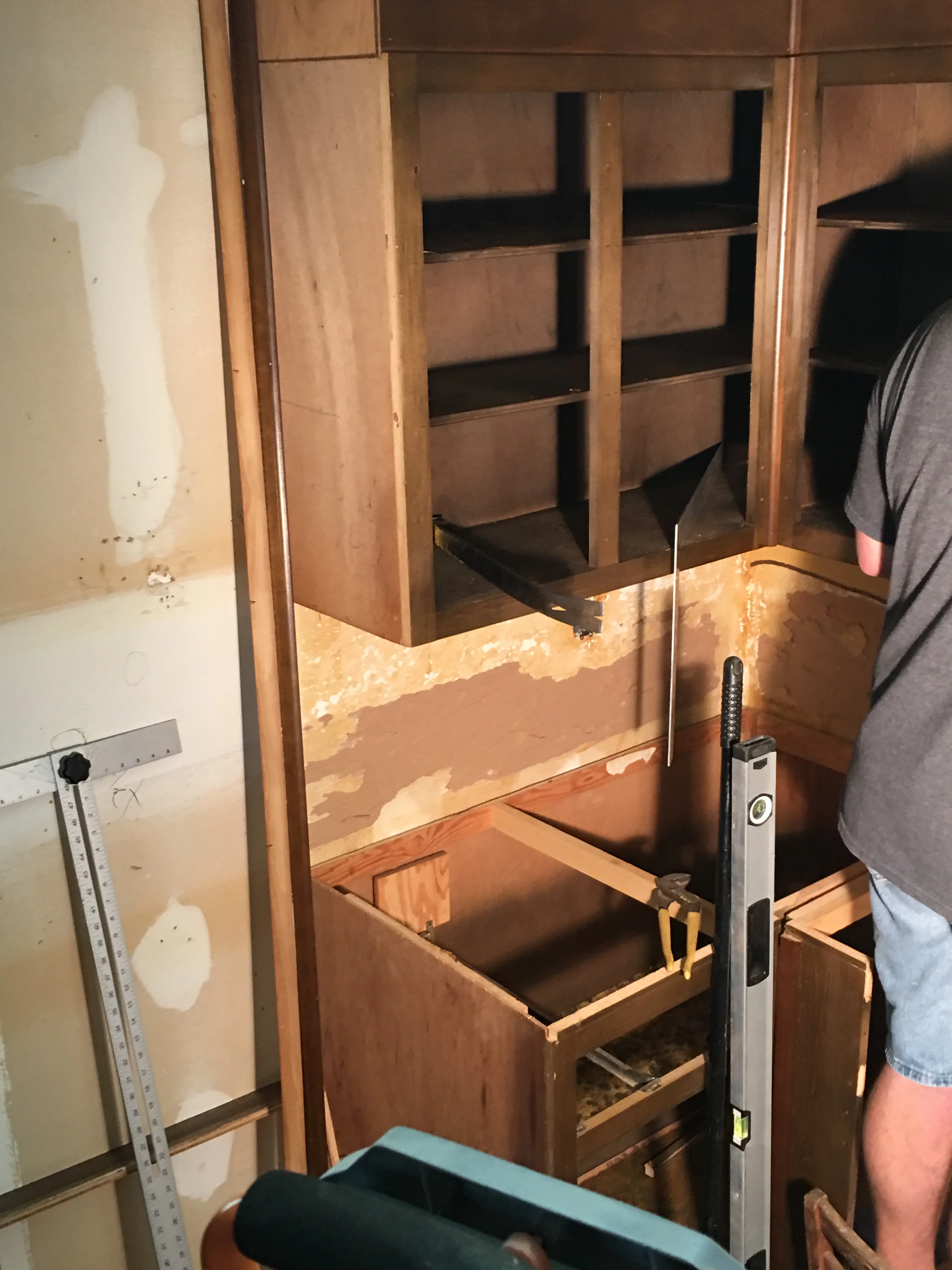 Custom wooden cabinetry with multiple shelves during installation phase