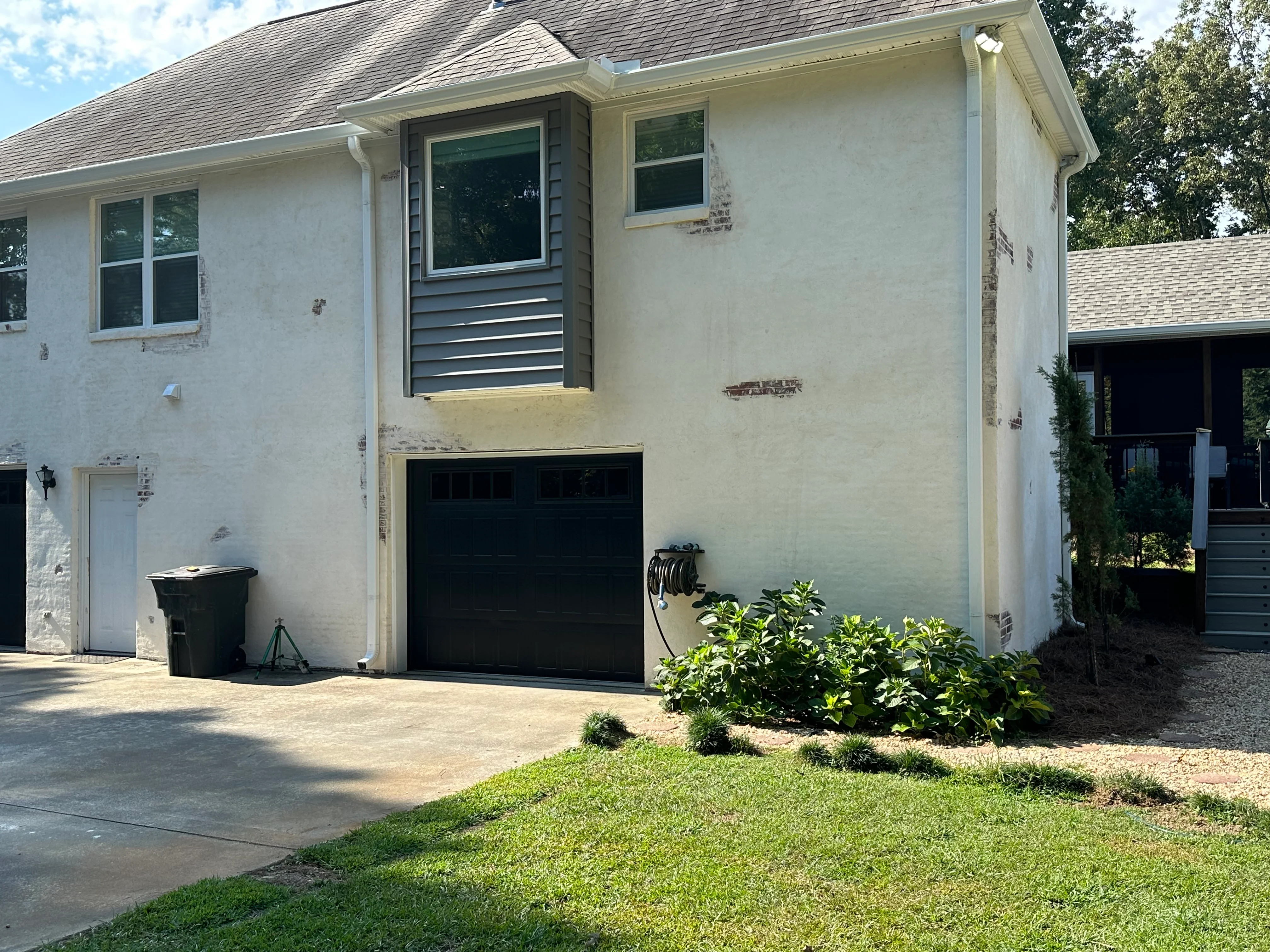 White stucco home with new black garage door and updated exterior finishes in Helena