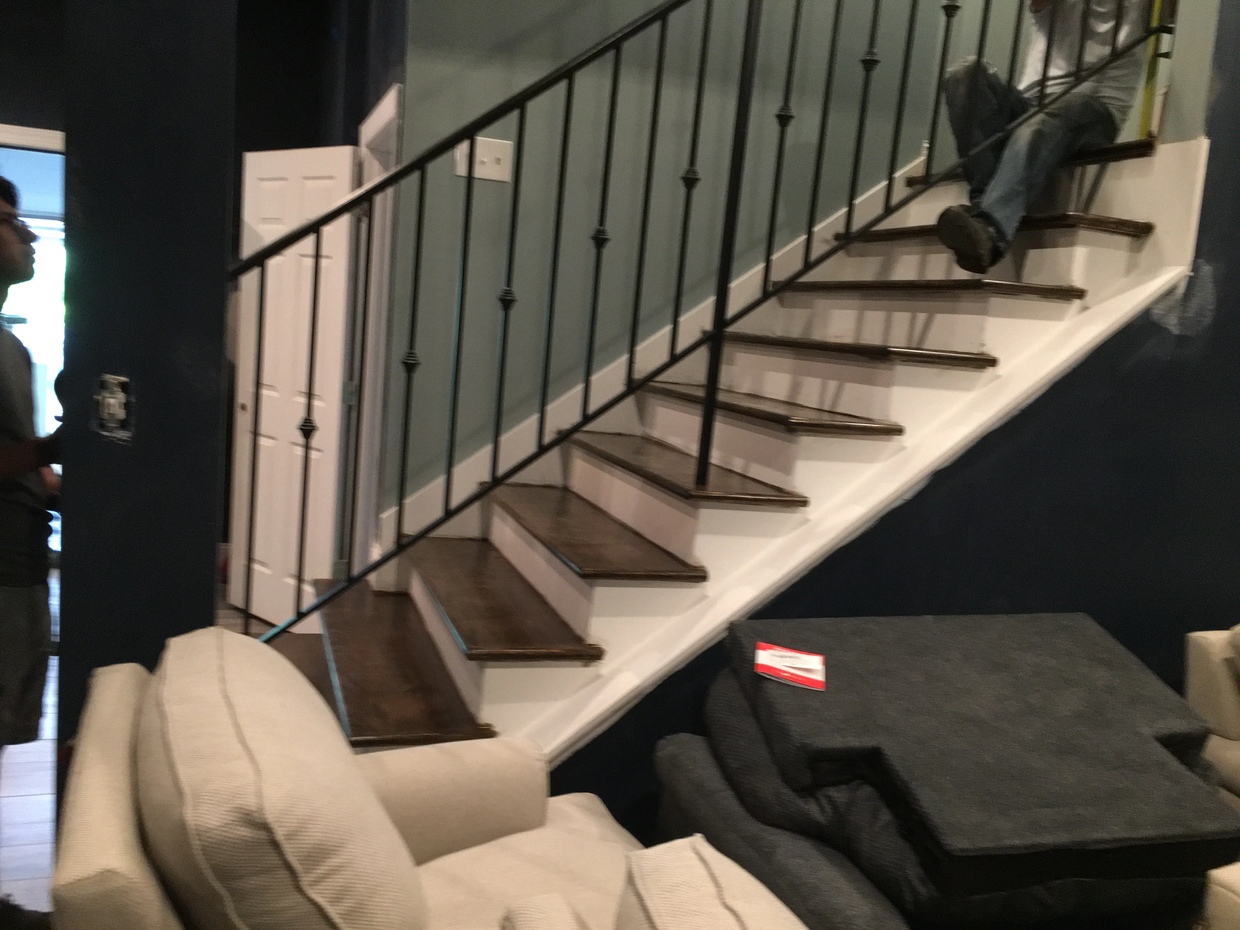 Modern staircase with white treads, dark wood nosing, and black metal railing