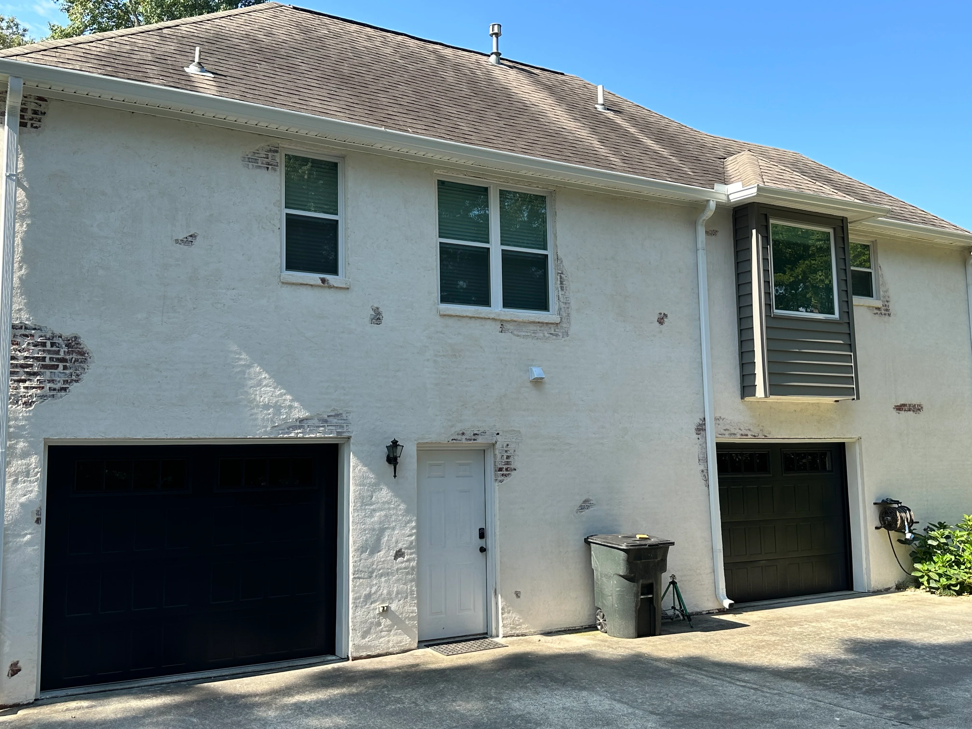 White stucco home with black garage doors and updated entry door in Helena