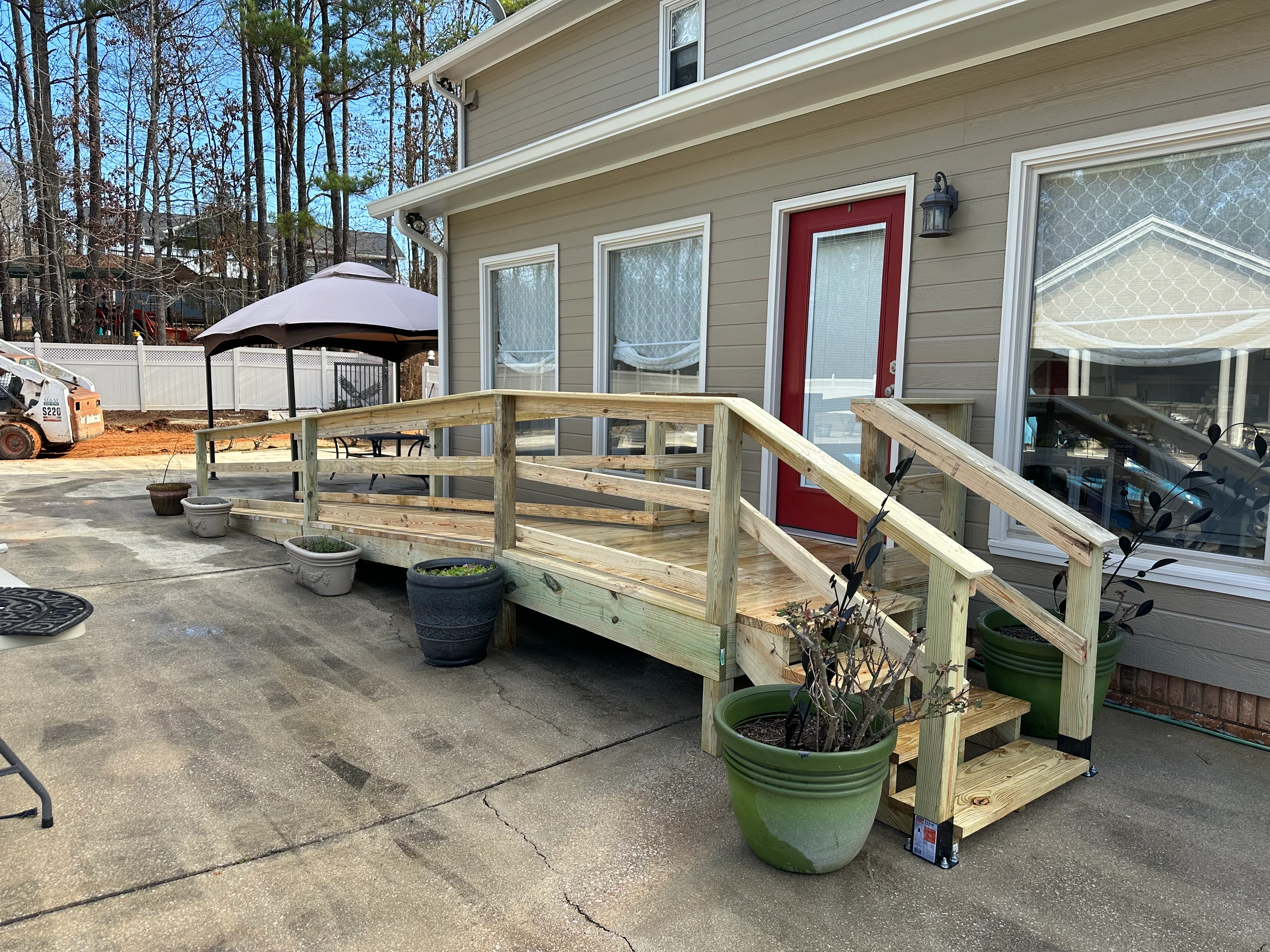 Newly constructed wooden deck with railings and planter boxes attached to home exterior