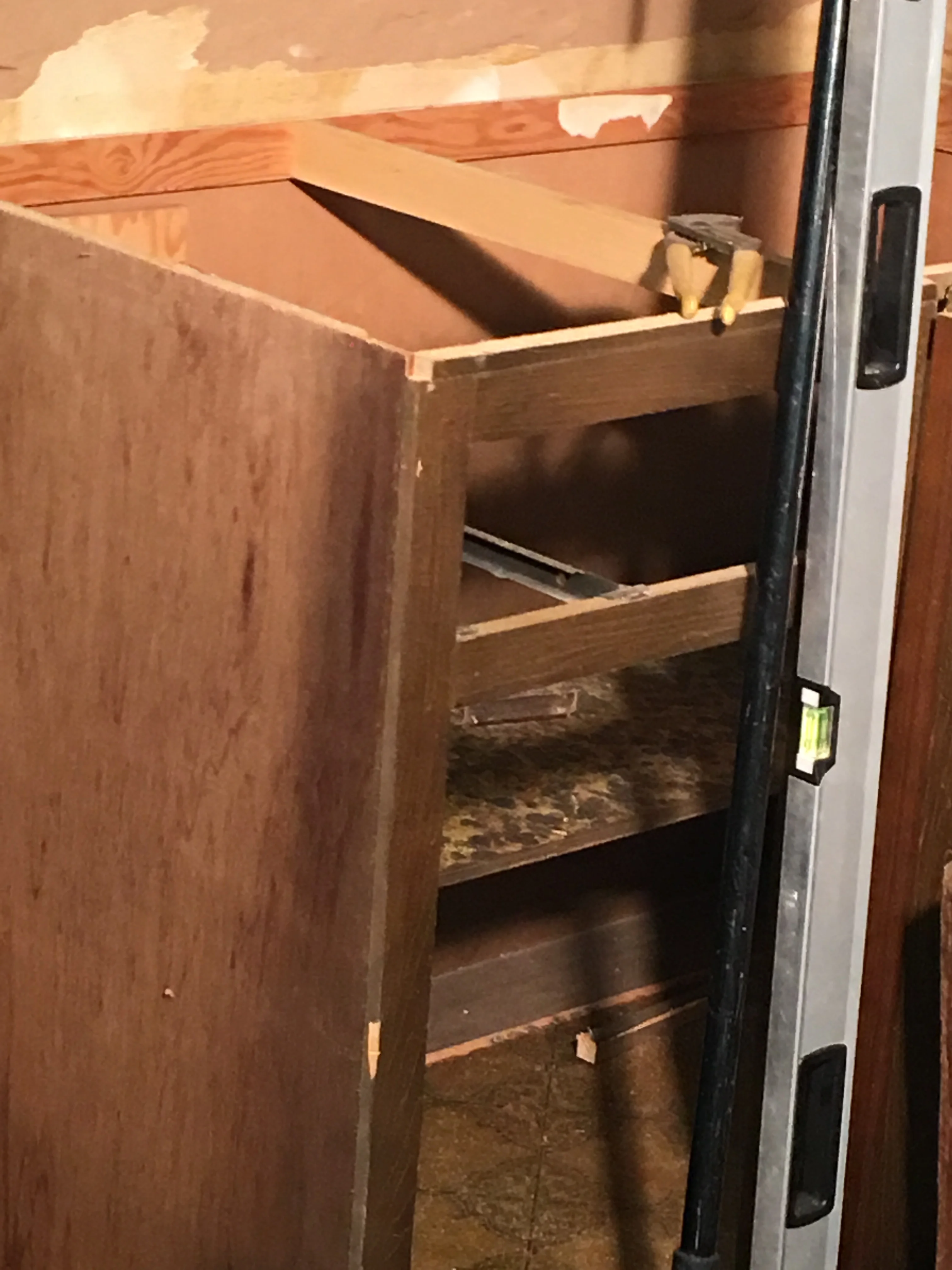 Wooden bathroom vanity cabinet with multiple drawers during installation phase
