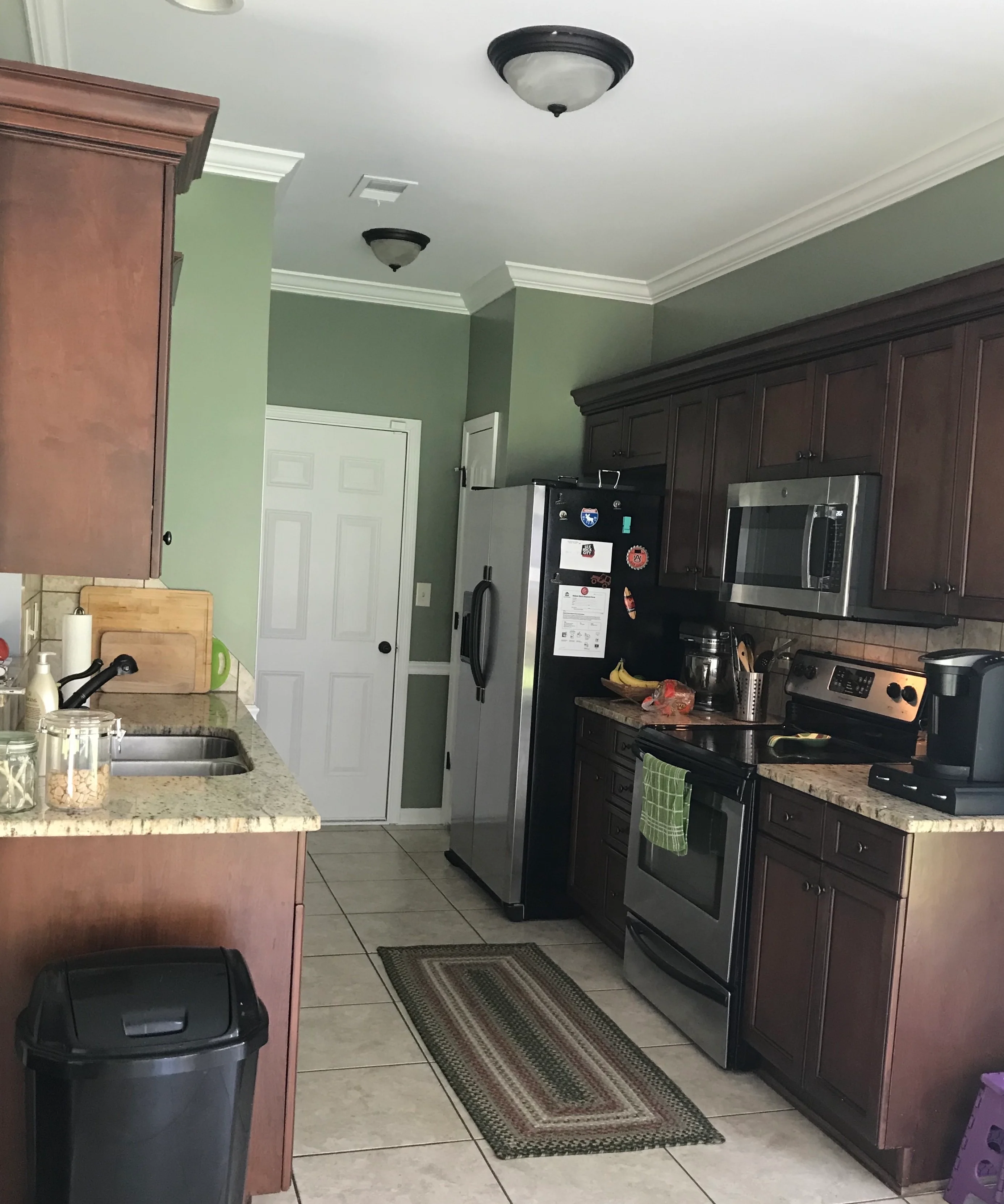 Modern kitchen with dark wood cabinets, granite counters, and stainless steel appliances
